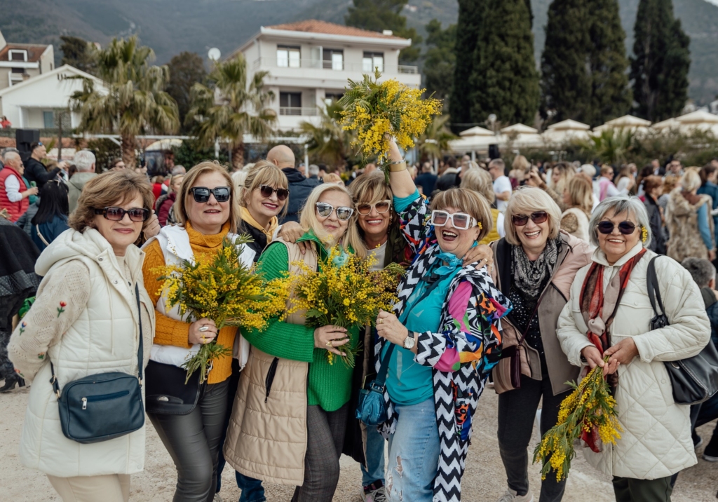 A Photo of women holding Mimosa flower, at Mimosa Festival Herceg Novi